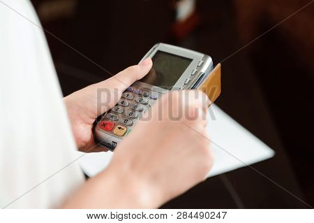 Hand Swiping Debit Card On Pos Terminal