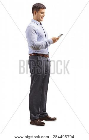 Full length shot of a young man in formal clotes holding a mobile phone and looking at it isolated on white background