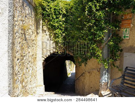 An Ancient Passage Covered In Vines With Signs Pointing To Ravello, Italy And Torre Dello Ziro