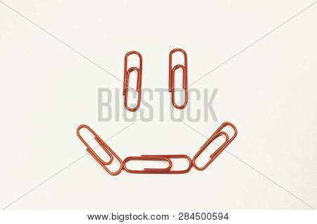 Colored Paperclips In The Shape Of The Smiling Face Isolated On The White Background. Stay Happy And