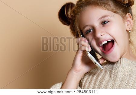 Little Girl In Oversized Sweater Happily Chatting On By Cell Phone With His Classmates Nude Beige Ba