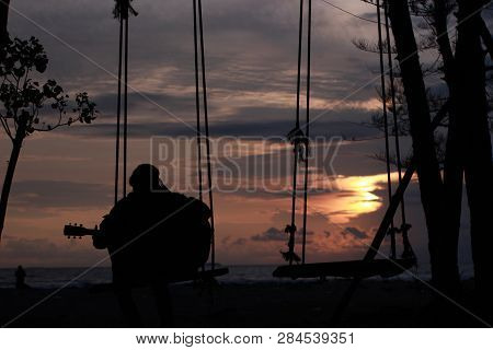 Play A Guiter With Beautiful Sunset In The Beach