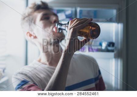 Man Drink Bear From Refridgerator At Night Time