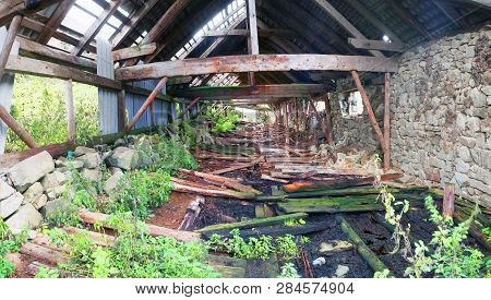 Destroyed Soviet Cowshed Farm In The Carpathian Mountains With Broken Walls And A Leaky Roof, Rotten