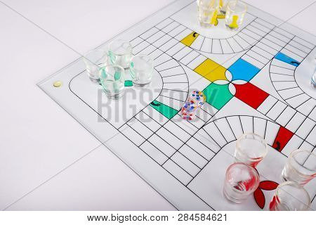 Typical Set Of Glass Parchis On Bench Background