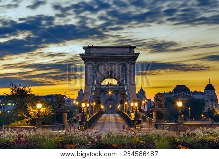 Chain Bridge In Hungary Budapest, Illuminated By Lanterns At Dawn.