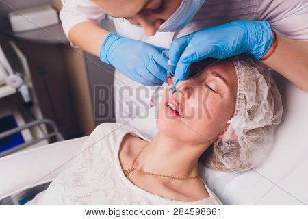 The Doctor Cosmetologist Makes Lip Augmentation Procedure Of A Beautiful Woman In A Beauty Salon.cos