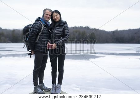 An Interracial Couple Outside At Burr Pond State Park In Winter In Torrington, Connecticut.