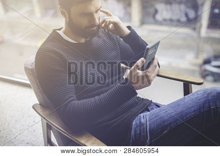 Bearded Hispanic Man In Black Pullover Using Mobile Phone Application For Mobile Blogging.confident 