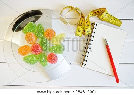 Marmalade On The Scales Next To A Notebook, A Pen And A Tape Measure. Counting And Recording The Amo