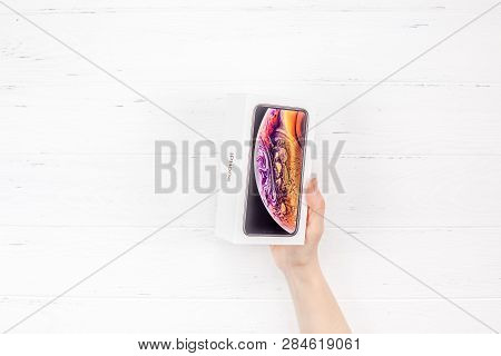 Berlin, Germany - December 09, 2018: Woman Hands Holding The Colorful Box Of The Latest Apple Iphone