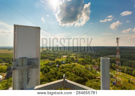 Telecommunication Tower With  Radio Antennas And Satellite Dishes Is Installed On The Rural On The G