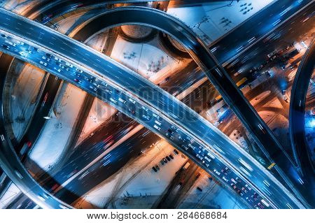 Aerial View Of Road In The Modern City At Night In Winter. Top View Of Traffic In Highway Junction W