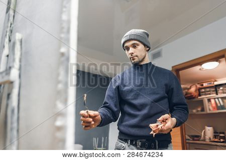 Portrait Of A Talented Caucasian Man Who Paints A Painting In A Studio With A Knife Palette. Creativ