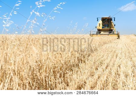 Agricultural Machinery Working On The Barley Tour With Sunny Day