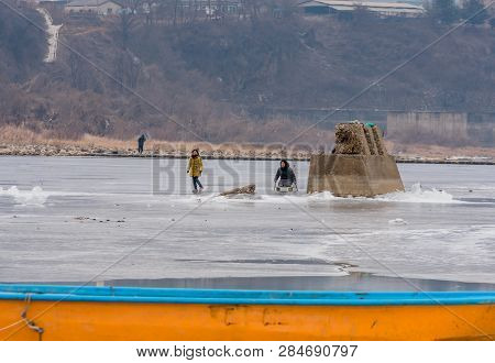 Pocheon, South Korea; February 2, 2019; Family Enjoying Winter Activities On Ice Of Frozen River Dur