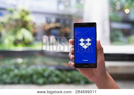 Chiang Mai, Thailand - May 05,2018: Man Holding Huawei With Dropbox On Screen. Dropbox Is A Service 