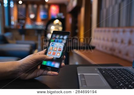 Chiang Mai, Thailand - May 05,2018: Man Holding Huawei With Icons Of E-commerce And Online Shopping 