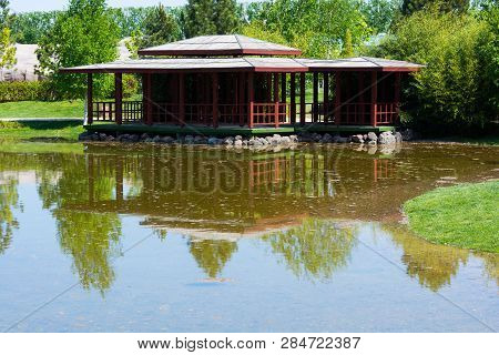 Wooden House By The Lake. Reflection In Rose Water.authentic Living Space