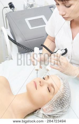 Facial Micro Current Cosmetology Procedure. Beauty Technology Treatment. Woman Face Therapy.