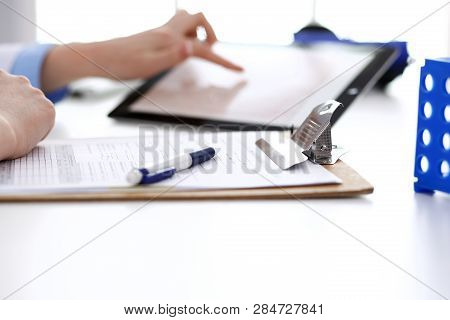 Doctor Working Table. Woman Physician Using Tablet Computer While Sitting In Hospital Office Close-u