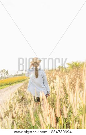 Girl Wearing A Hat Sitting Looking At Desho Grass.
