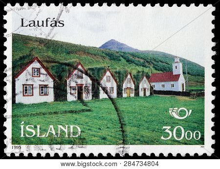 Luga, Russia - February 13, 2019: A Stamp Printed By Iceland Shows View Of The Turf Houses And Churc