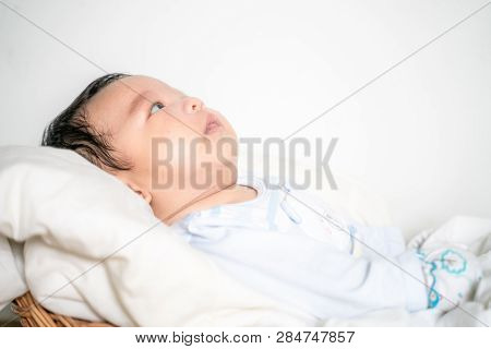 Infant Baby Lying On Blanket In Wood Baket On White Background