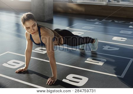 Serious-looking Determined Sporty Fit Woman In Activewear Bra And Sportswear Leggings Standing In Pl