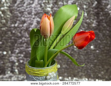 Bouquet Of Delicate Spring Red Tulips On A Blurred Metal Background