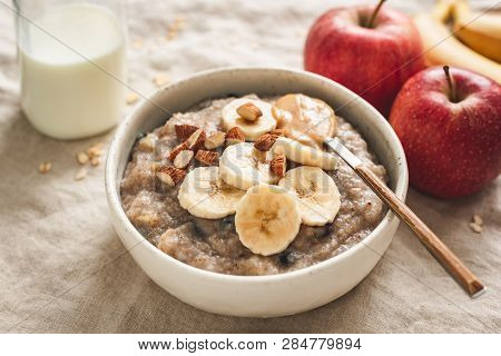 Healthy Breakfat Oatmeal Porridge Bowl With Banana, Almonds, Apple, Raisin. Vegetarian Breakfast