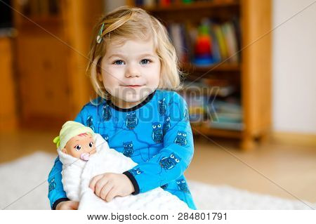 Adorable Cute Little Toddler Girl Playing With Doll. Happy Healthy Baby Child Having Fun With Role G