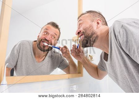 Funnny Guy Taking Care Of His Oral Hygiene, Brushing Teeth During Morning Bathroom Routine.
