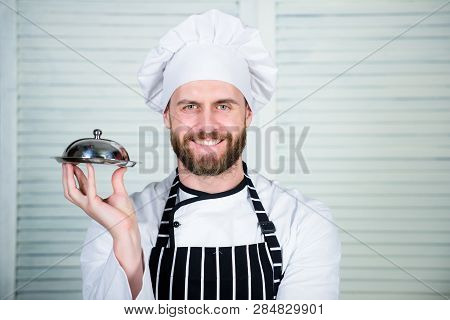 Chefs Dish. Man Cook Hat And Apron Hold Meal Covered With Lid. Delicious Meal Presentation. Haute Cu