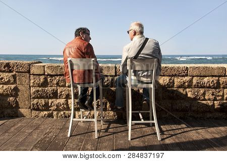 Two Men Talk To Each Other Sitting On Chairs