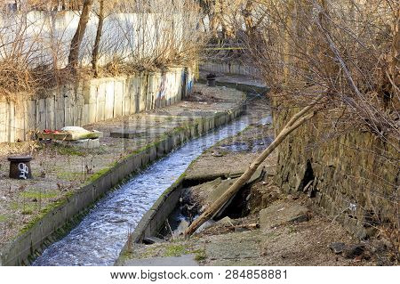 The Dirty River Lybid Flows Along A Channel Enclosed In A Concrete Chute.