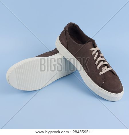 Close Up Of A Brown Mens Top-sider Boat Shoes With White Sole On Blue Background With Reflection. Fa