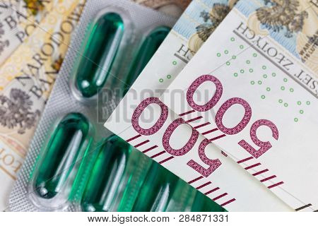 Polish currency zloty banktotes over medicine pills representing rising health care costs