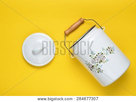 Enameled Milk Can On Yellow Pastel Background. Top View