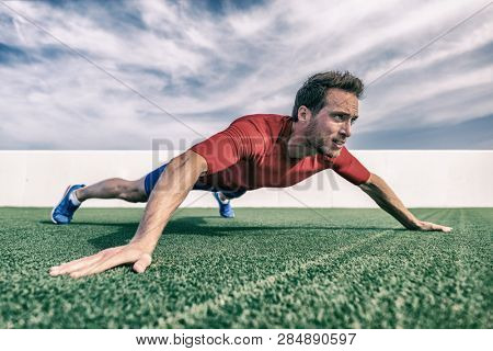 Wide grip pushup push-up variation advanced chest exercise demonstration by male trainer athlete man training at outdoor gym.
