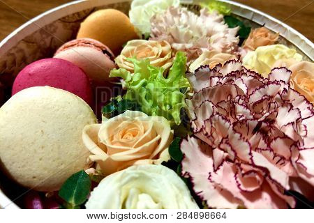 Delicious Colourful Macaroons Cookies In A Gift Box Along With Blossoming Flower Bouquet Of Roses, M