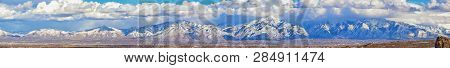Winter Panoramic View Of Snow Capped Wasatch Front Rocky Mountains, Great Salt Lake Valley And Cloud