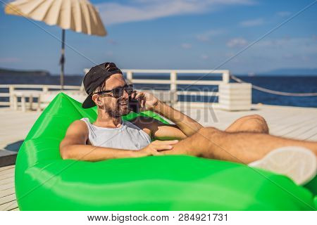 Young Man Enjoying Leisure, Lying On The Air Sofa Lamzac, Near The Sea
