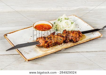 Skewers, Onions, Pita Bread, Sauce On A White Plate