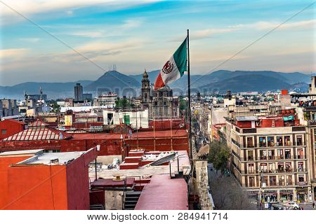 Mexico City, Mexico -  January 2, 2019 Santo Domingo Church Mexican Flag Mountains Zocalo Mexico Cit