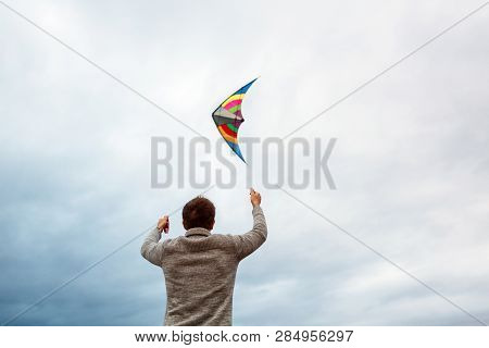 Young Men Flying A Kite On The Beach