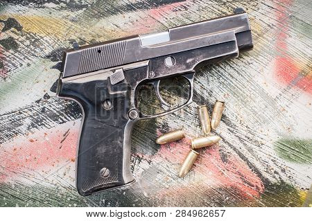 Top View Of Gun And Ammunition On The Table