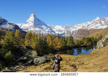 Hiker Is Photographing Matterhorn At The Grindjisee Lake. Matterhorn Is The Most Famous Alps Peak In