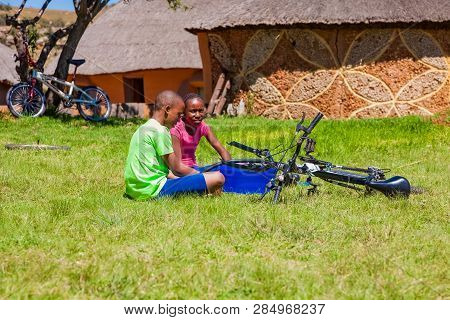 African Children Fixing A Puncture On A Bike