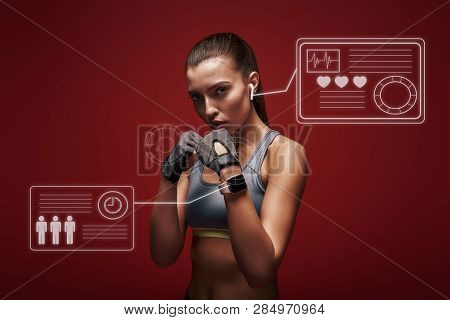 Modern Athlete. Sportswoman Standing Concentrated In Gym Gloves Over Red Background. Game Concept Wi